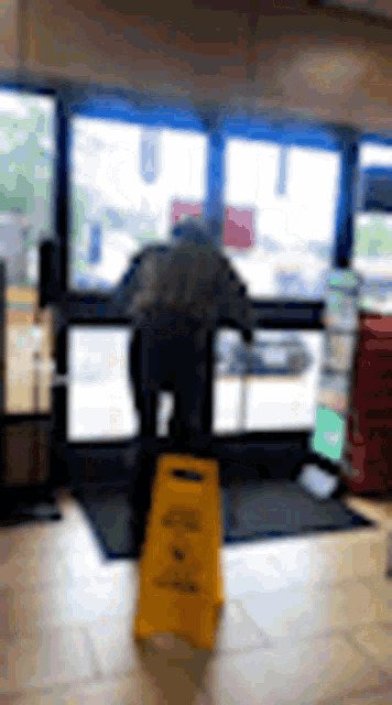 a man is standing on a yellow wet floor .