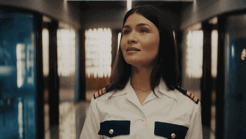 a woman in a white and blue uniform is looking up