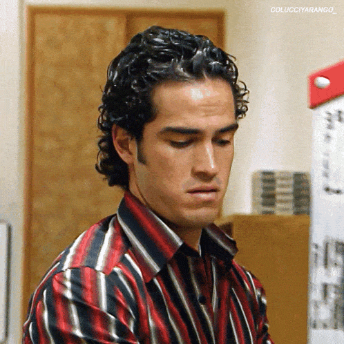 a man with curly hair is wearing a red and black striped shirt with the caption colucciyarango_