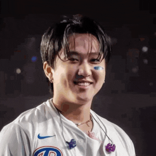 a close up of a man wearing a white shirt and earbuds .