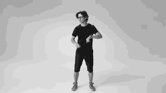 a black and white photo of a man dancing in a room .
