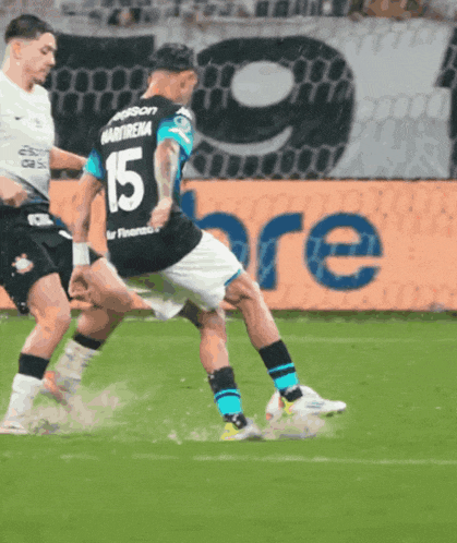 a soccer player with the number 15 on his back kicks the ball