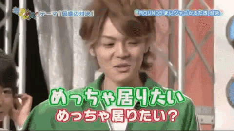 a man in a green shirt is talking in a language other than english