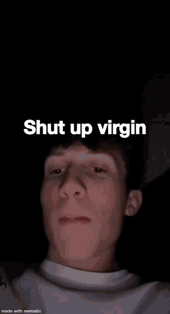 a young man is smoking a cigarette with the words `` shut up virgin '' written on the screen .