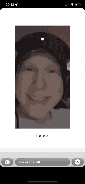 a phone screen shows a person wearing a hat and smiling with the word love below them