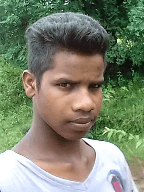 a young man wearing a white shirt with a shark on it looks at the camera