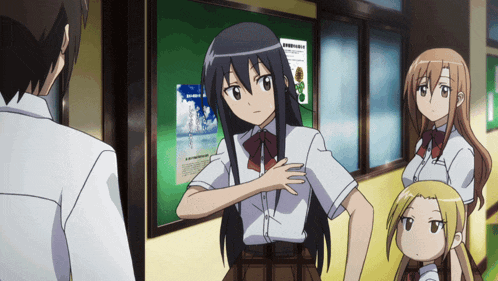 a group of anime characters are standing in a hallway with a poster on the wall that says ' a ' on it