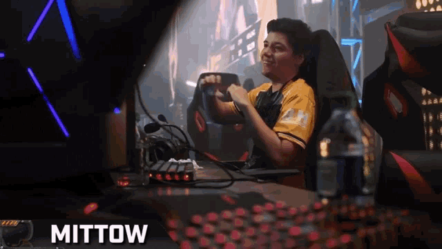 a man sitting in a chair with the name mittow on the bottom right