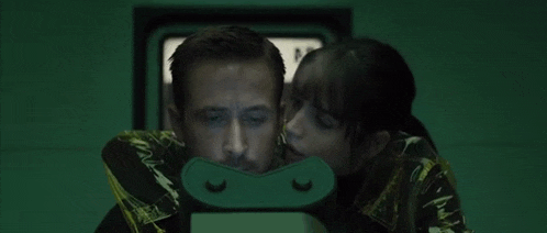 a woman is kissing a man on the cheek while they are looking at something .