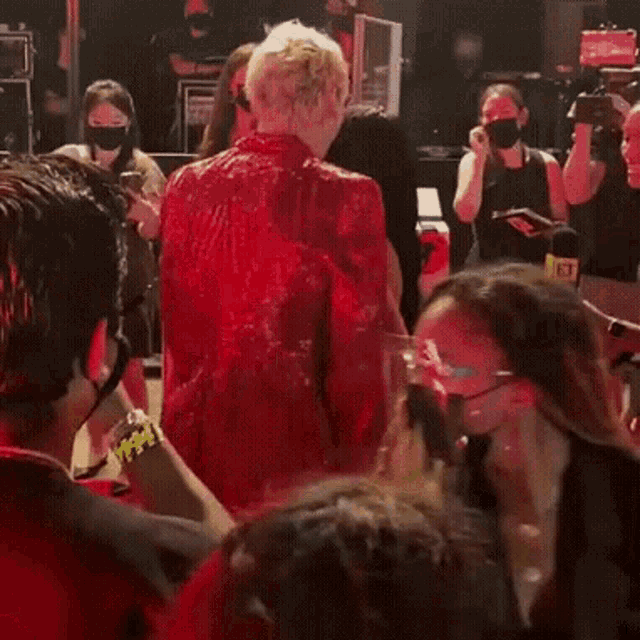 a group of people are standing on a red carpet .