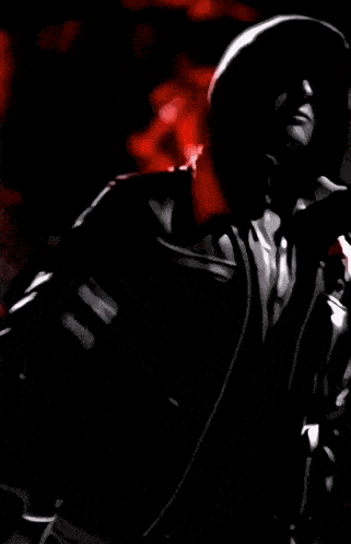 a close up of a person 's face with a red light behind them