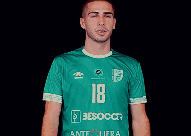 a man wearing a green shirt with the number 18 on the front