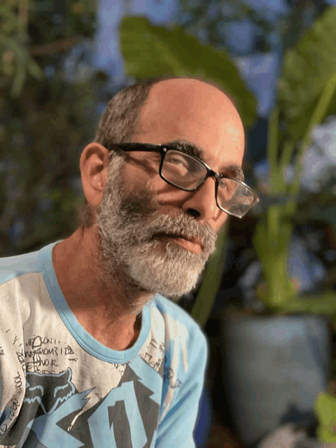 a man with a beard wearing glasses and a shirt that says fox on it