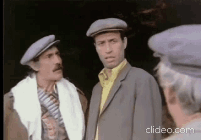 a group of men are standing next to each other wearing hats .