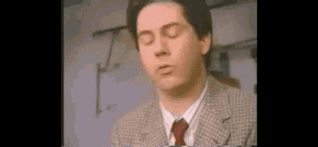 a man in a suit and tie is making a face .