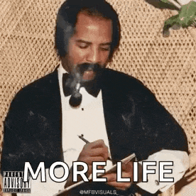 a man in a tuxedo is smoking a cigarette and writing on a piece of paper .