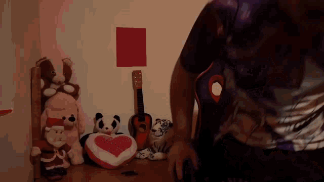 a man in a purple shirt is standing in front of a table full of stuffed animals