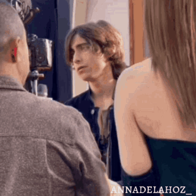 a man and a woman are standing next to each other talking to each other .