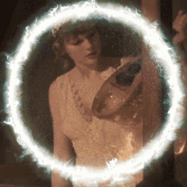 a woman in a white dress holds a pair of shoes in front of a circle of fire
