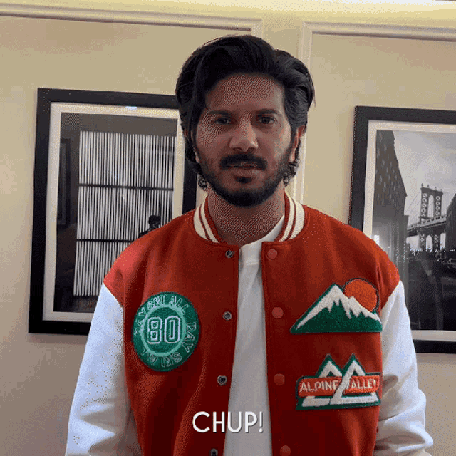a man wearing a red and white jacket with alpine alley written on it