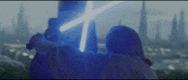 two people are holding lightsabers in front of a city skyline