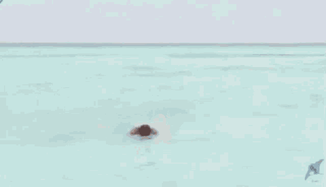 a shirtless man in blue shorts is walking across a beach