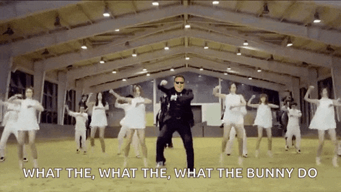 a man in a suit is dancing in front of a group of women with the words what the what the what the bunny do