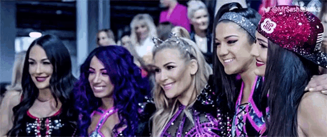 a group of women are posing for a picture together and smiling for the camera .