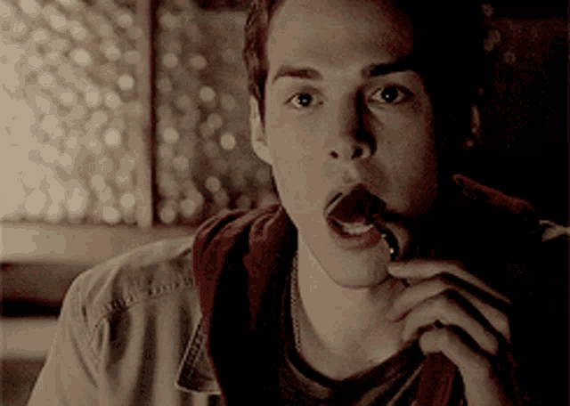 a young man eating a piece of chocolate with a spoon