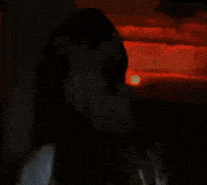a pixelated image of a woman in front of a red sky