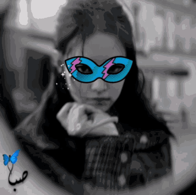 a black and white photo of a girl wearing a blue mask with a lightning bolt on it