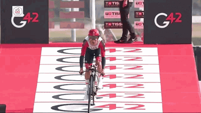 a person is riding a bike on a track that says g42 on it