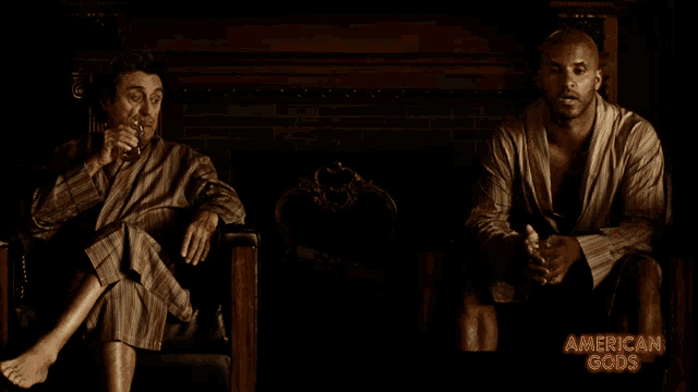 two men sitting next to each other with the words american gods on the bottom right