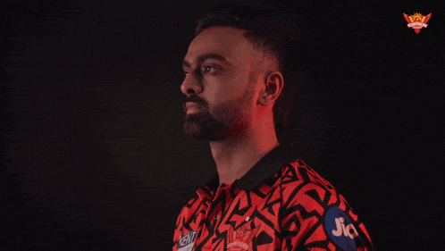 a man in a red and black shirt with jio on his arm