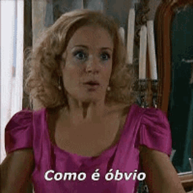a woman in a pink dress says " como e obvio " in a foreign language .
