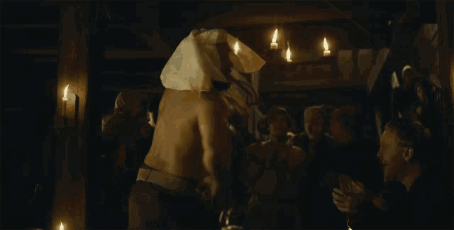 a man without a shirt is dancing in a dark room