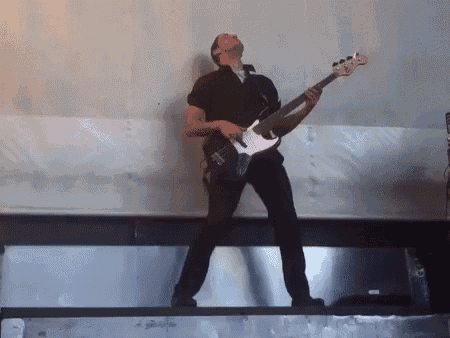 a man is playing a bass guitar on a stage