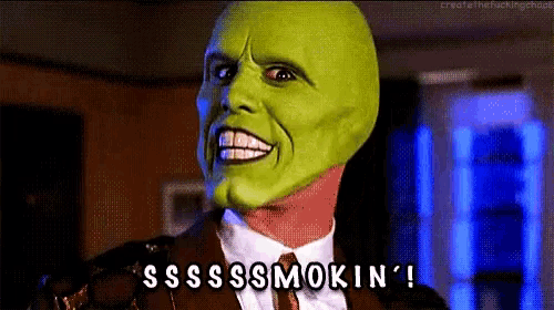a man in a suit and tie with a green mask on his face says sss smokin '