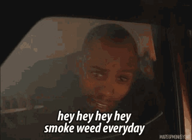 a man is sitting in the back seat of a car and smoking weed .