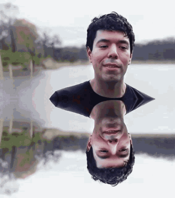 a man 's head is reflected in the water