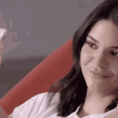 a close up of a woman sitting on a couch looking at the camera .