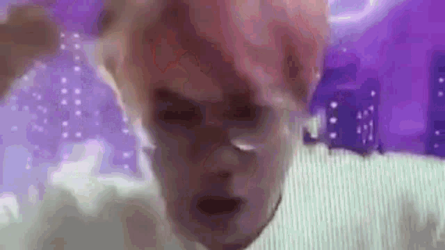 a close up of a person 's face with pink hair and purple background .