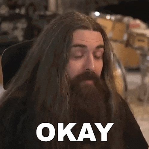 a man with long hair and a beard has the word okay on his face