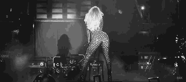 a black and white photo of a woman dancing on stage .