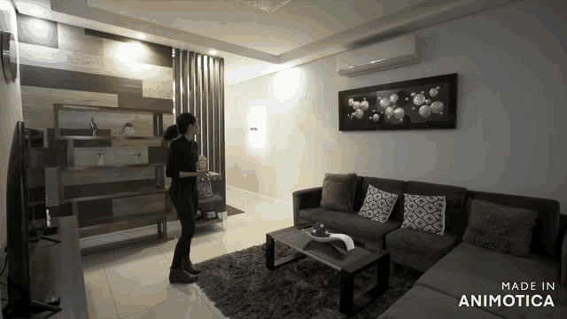 a woman stands in a living room with the words made in animatica on the bottom right