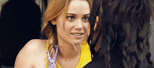 two women are looking at each other and one is wearing a yellow top