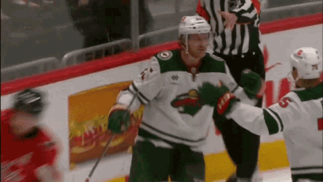 a hockey player with the number 6 on his jersey hugs another player