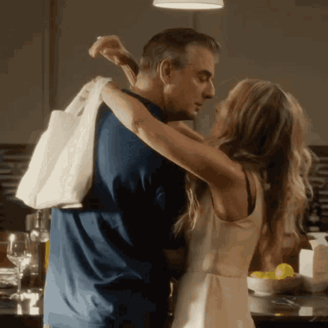 a man and woman are hugging in a kitchen