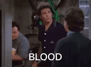 a group of men are standing next to each other in a room and one of them is talking about blood .
