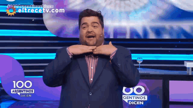 a man in a suit is standing in front of a sign that says 100 argentinas dicen